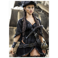 A woman dressed as a pirate, wearing a black hat, long braids, a black corset-style top, dark cape, and accessories, standing in front of a blurred ship background.